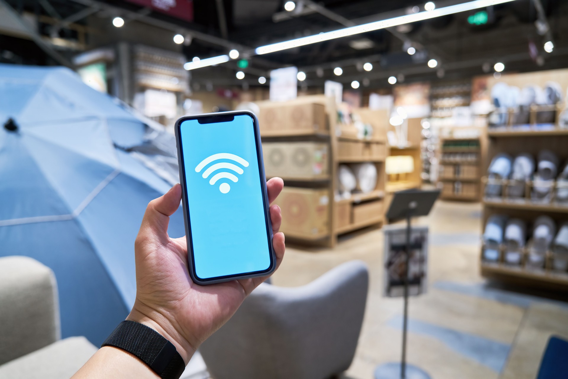 Man hands using smartphone with wifi icon abstract background in department store